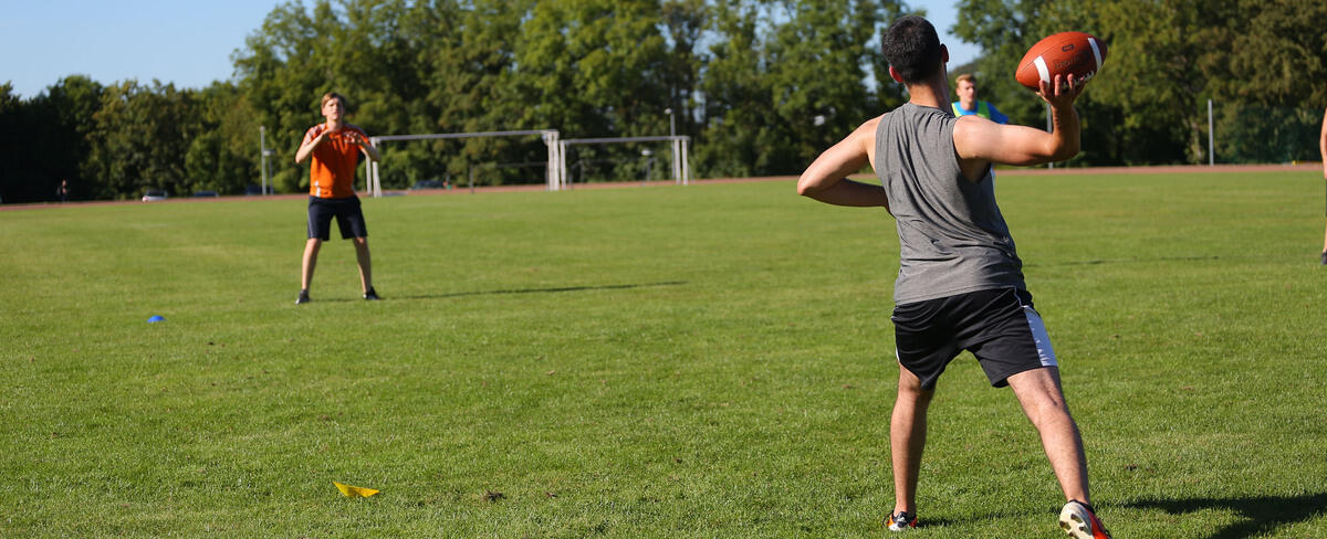 Zwei Personen werfen sich einen Football zu
