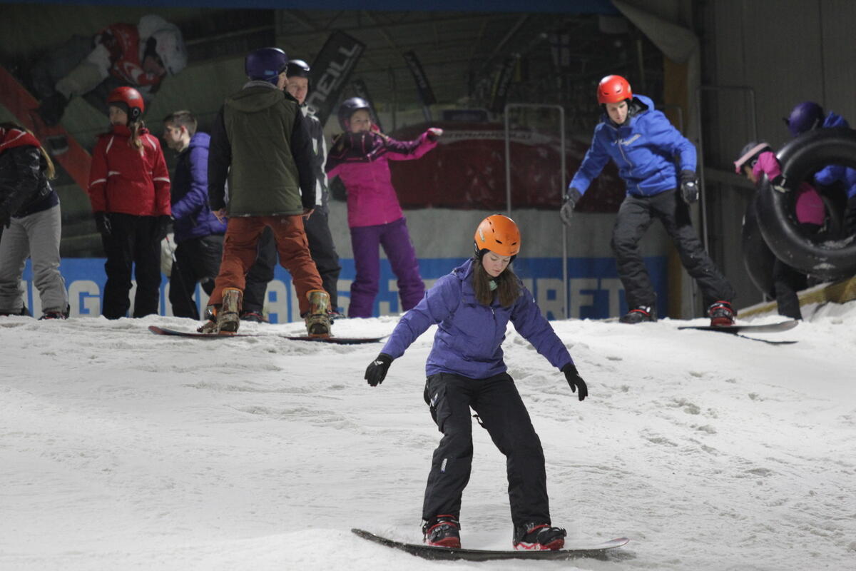 Eine Snowboarderin bei den ersten Stehversuchen