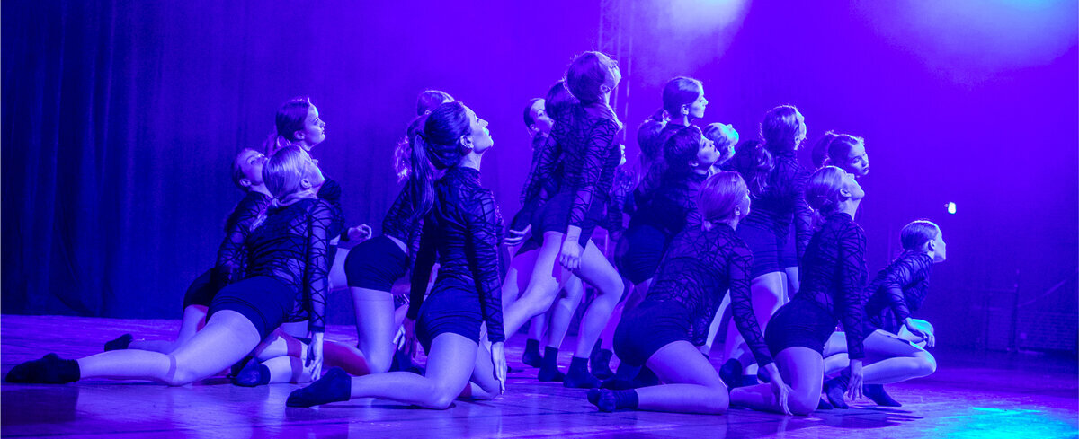 Contemporary Tänzerinnen knien auf dem Boden und schauen alle nach Rechts