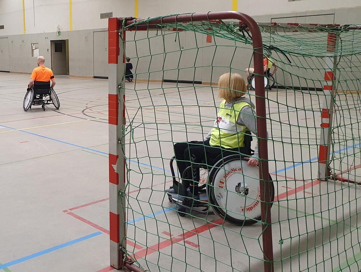Rollstuhlhandballspielende auf dem Feld und im Tor