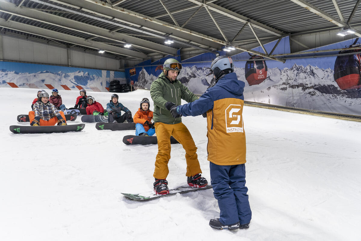 Snowboarder mit Trainer auf der Piste