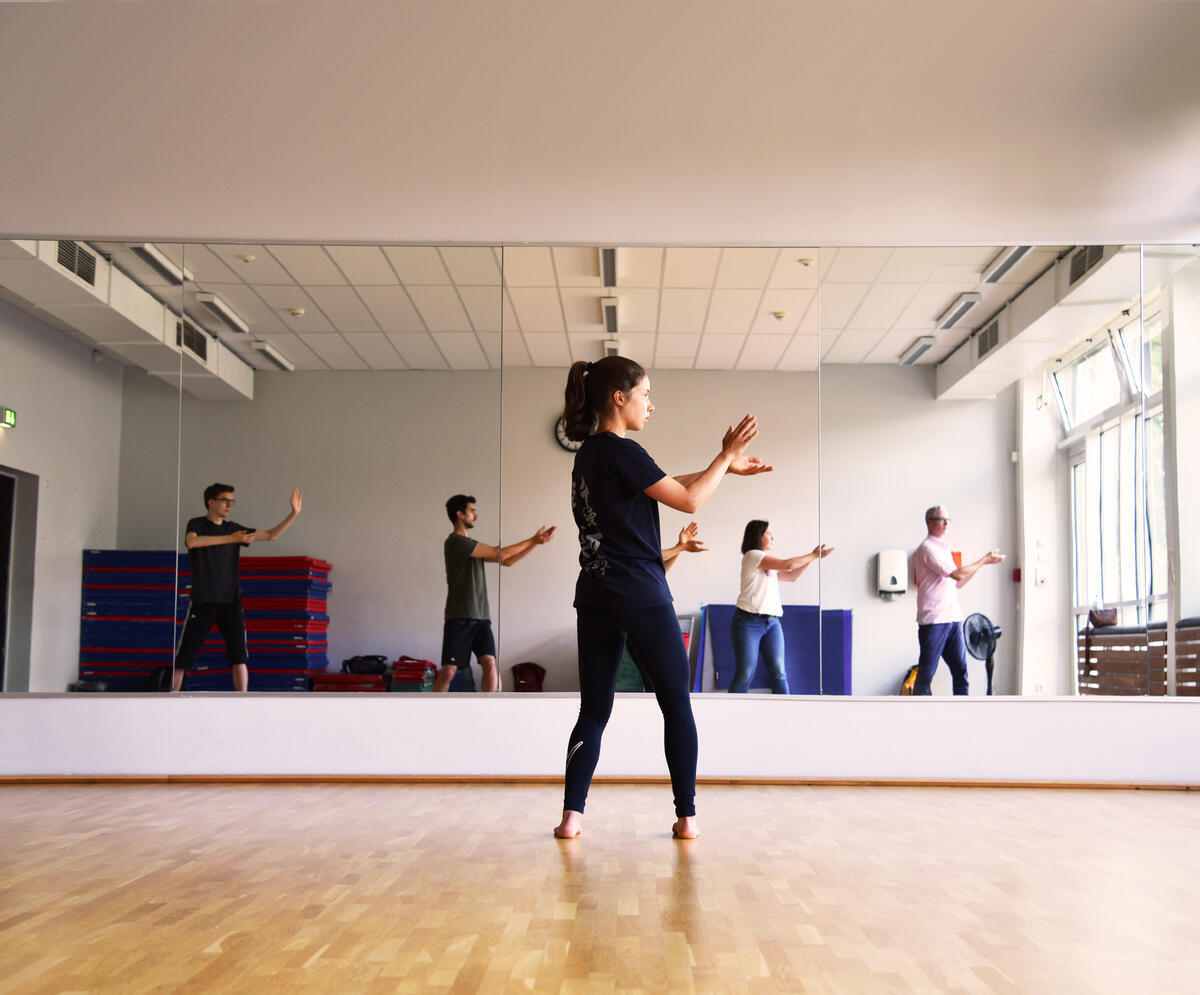 Personen machen Übungen vor einem Spiegel