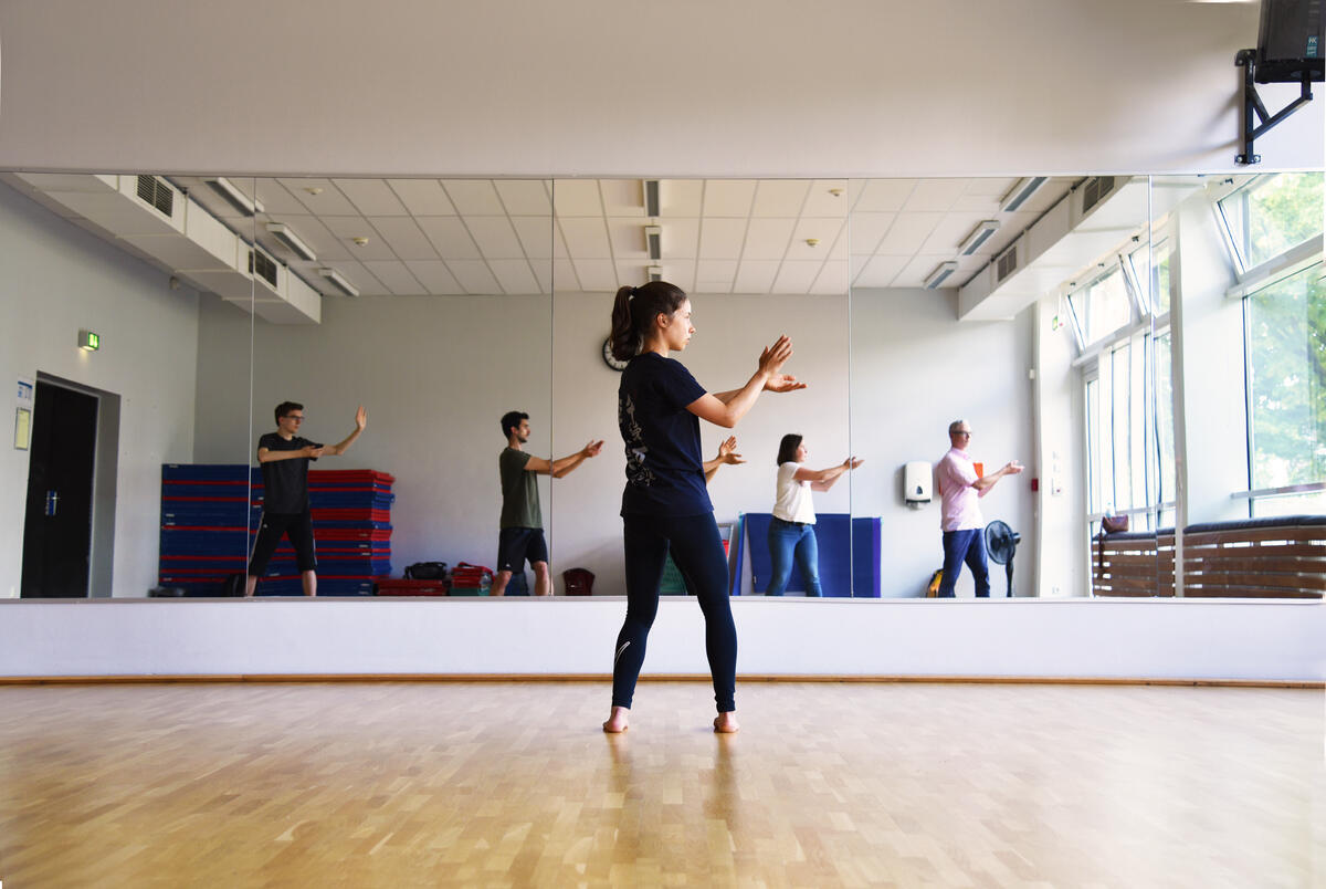 Trainerin macht Übungen vor einem Spiegel  vor