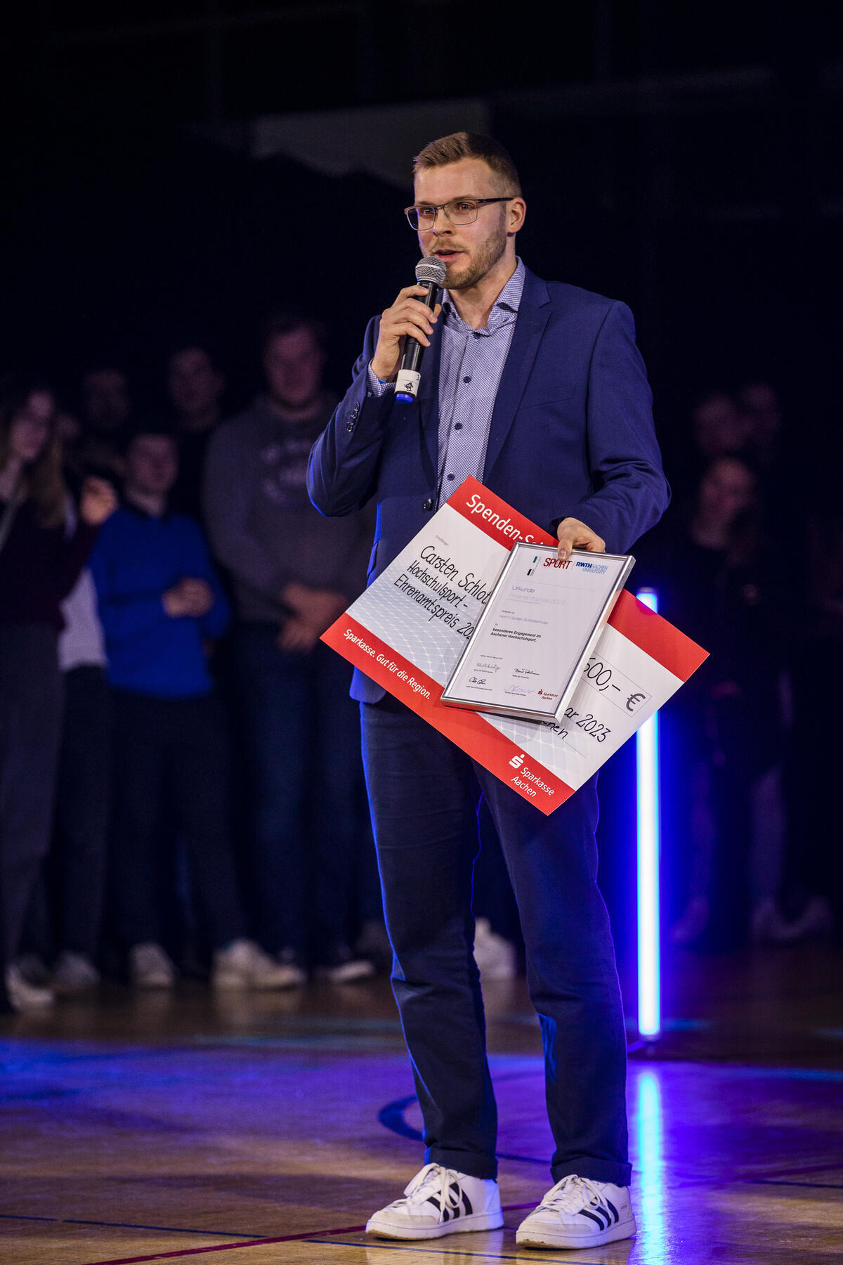 Carsten Schlotterhose mit Preis-Scheck und Mikrofon