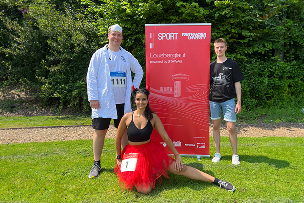 drei personen stehen auf Gras in Kostümen